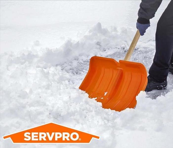Pictured is someone shoveling snow with the SERVPRO logo on it. 