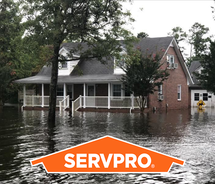 Pictured is a house that is surrounded by resulting flood water. 